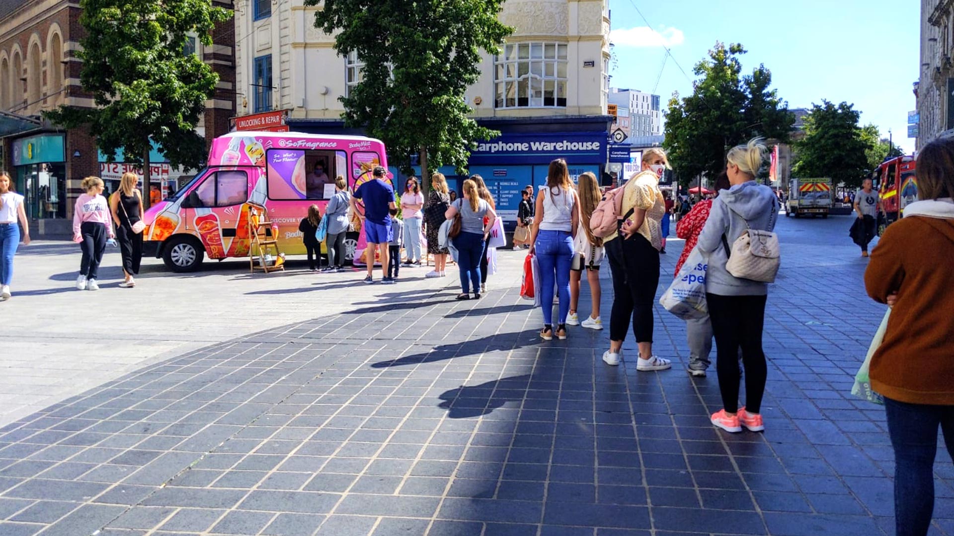 Long queue of consumers lining up at the custom-branded iMP promotional sampling van during the So Fragrance high-street roadshow