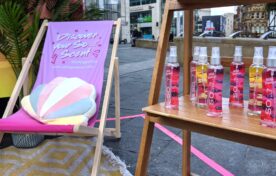 Consumer scanning a retail discount QR code at a mobile beauty sampling event to drive direct-to-consumer online sales