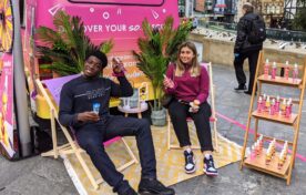 Consumers relaxing in branded deckchairs while sampling body mists at an outdoor iMP experiential event footprint
