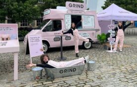 Branded Pink Grind Ice Cream van with open serving window for sampling at activation event