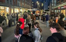 Crowd of students gathered around Papa Johns x Tango van taking photos and sharing on social media during campus sampling