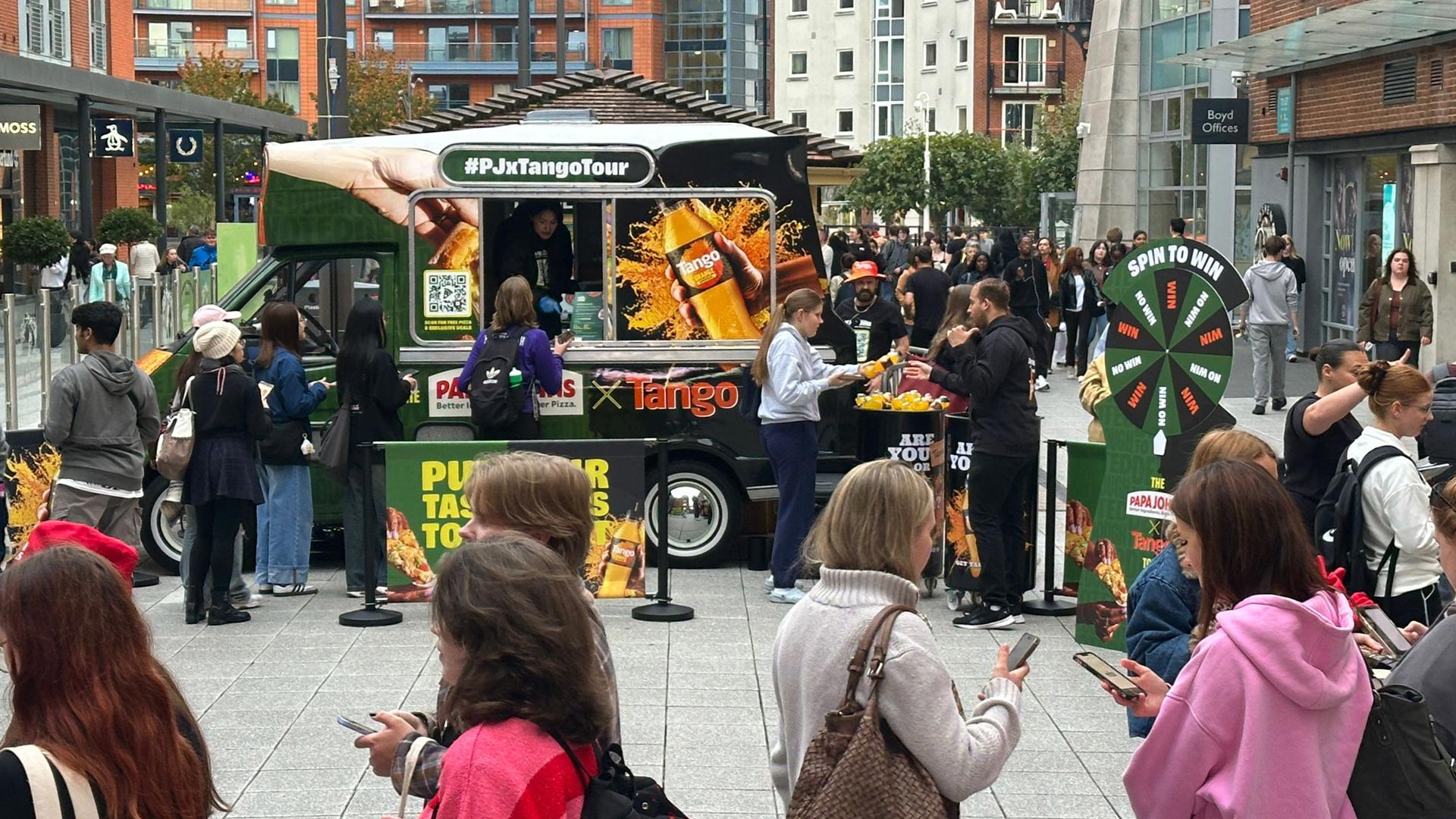 Papa Johns x Tango branded sampling van on university campus surrounded by students during iMP sampling tour